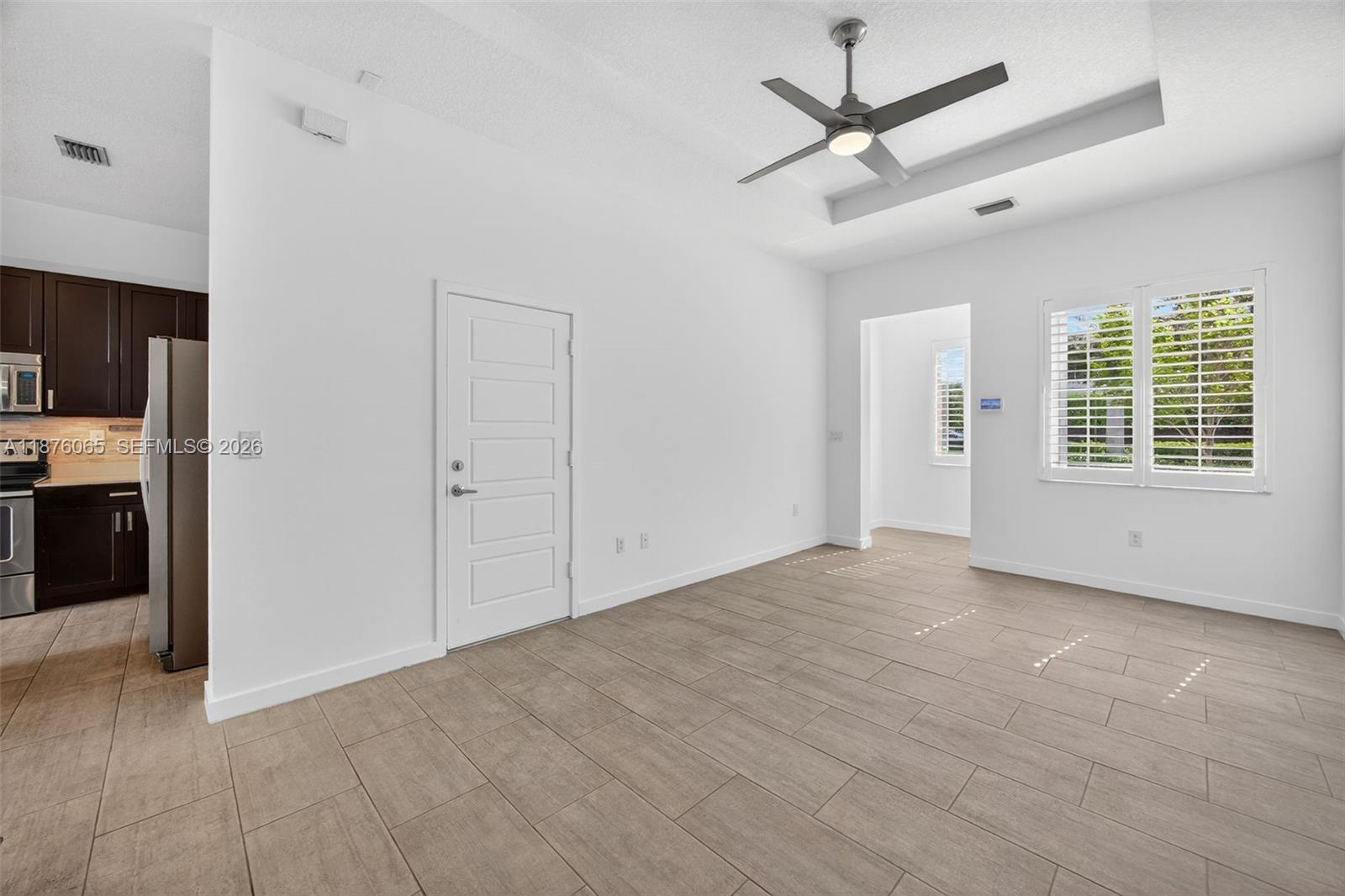 17606 Southwest 149th Place, Unit 17606 Miami, FL 33187 - Photo 8 of 69 a view of an empty room with a window and a kitchen