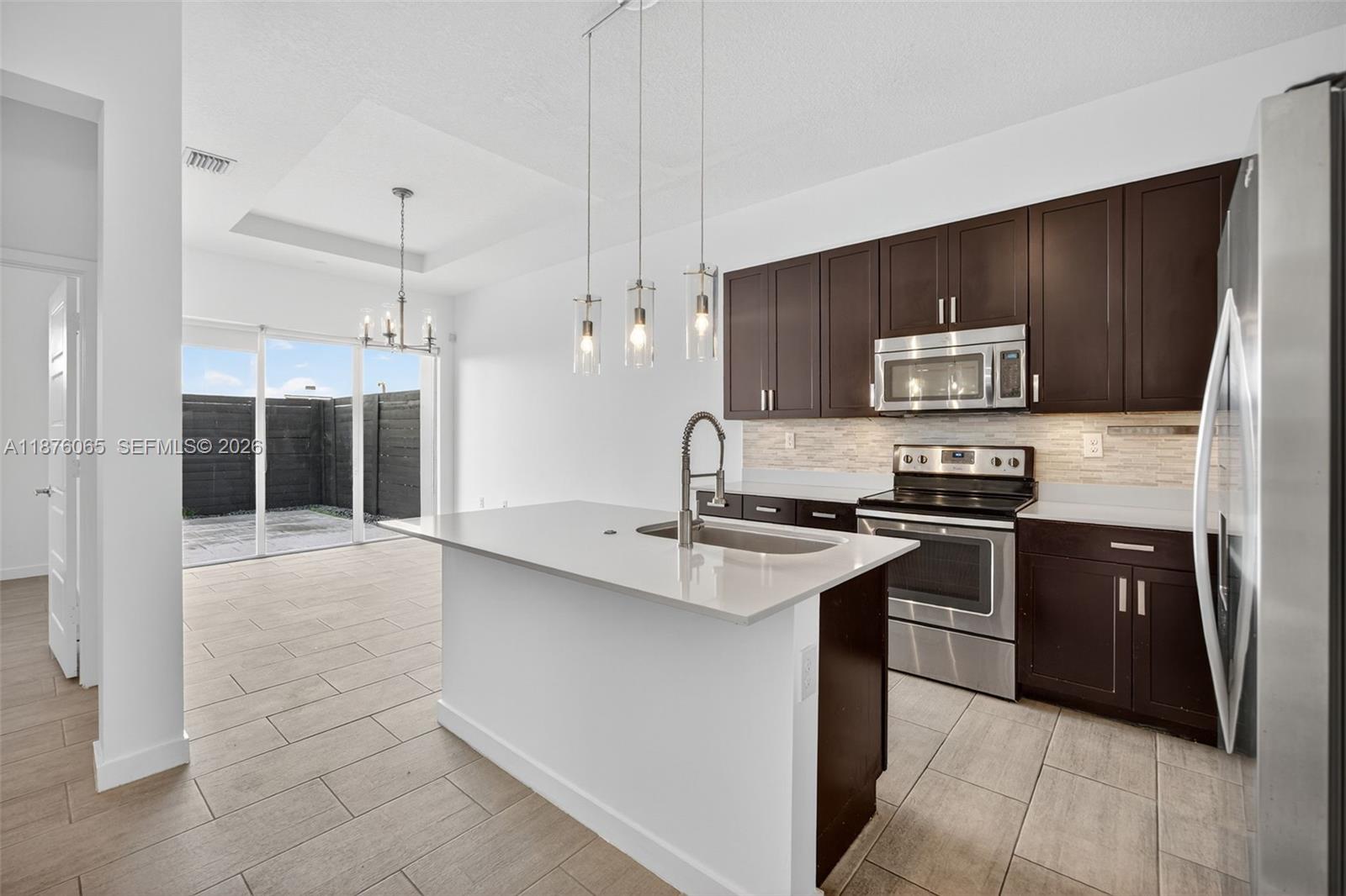 17606 Southwest 149th Place, Unit 17606 Miami, FL 33187 - Photo 10 of 69 a kitchen with stainless steel appliances granite countertop a sink stove and refrigerator