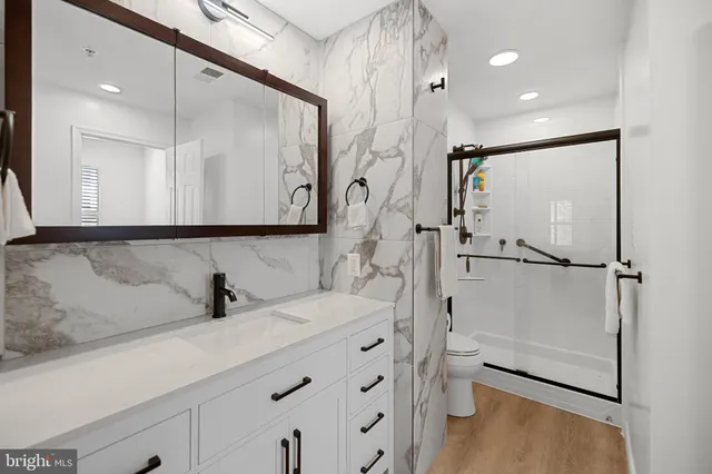 a bathroom with a shower sink vanity and mirror