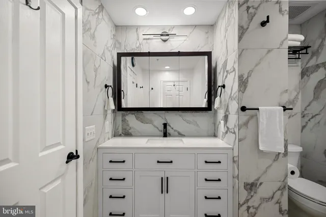 a bathroom with a granite countertop sink vanity mirror and a