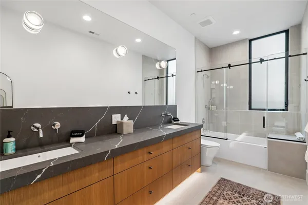 a spacious bathroom with a double vanity sink a mirror and a bathtub