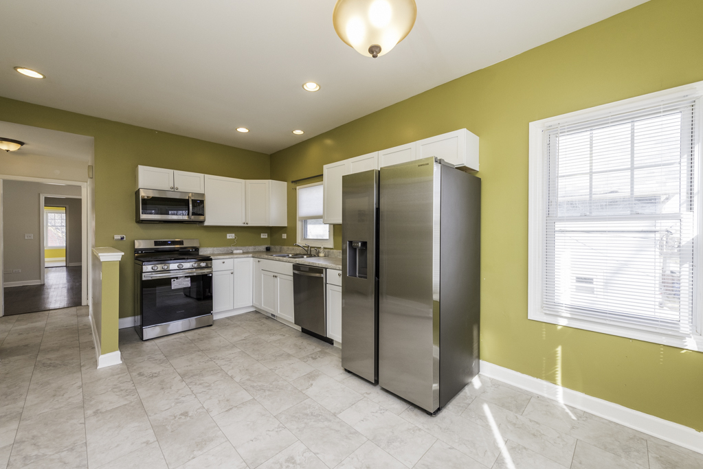 515 2nd Street, Unit 2 Waukegan, IL 60085 - Photo 14 of 27 a kitchen with stainless steel appliances granite countertop a refrigerator and a stove top oven