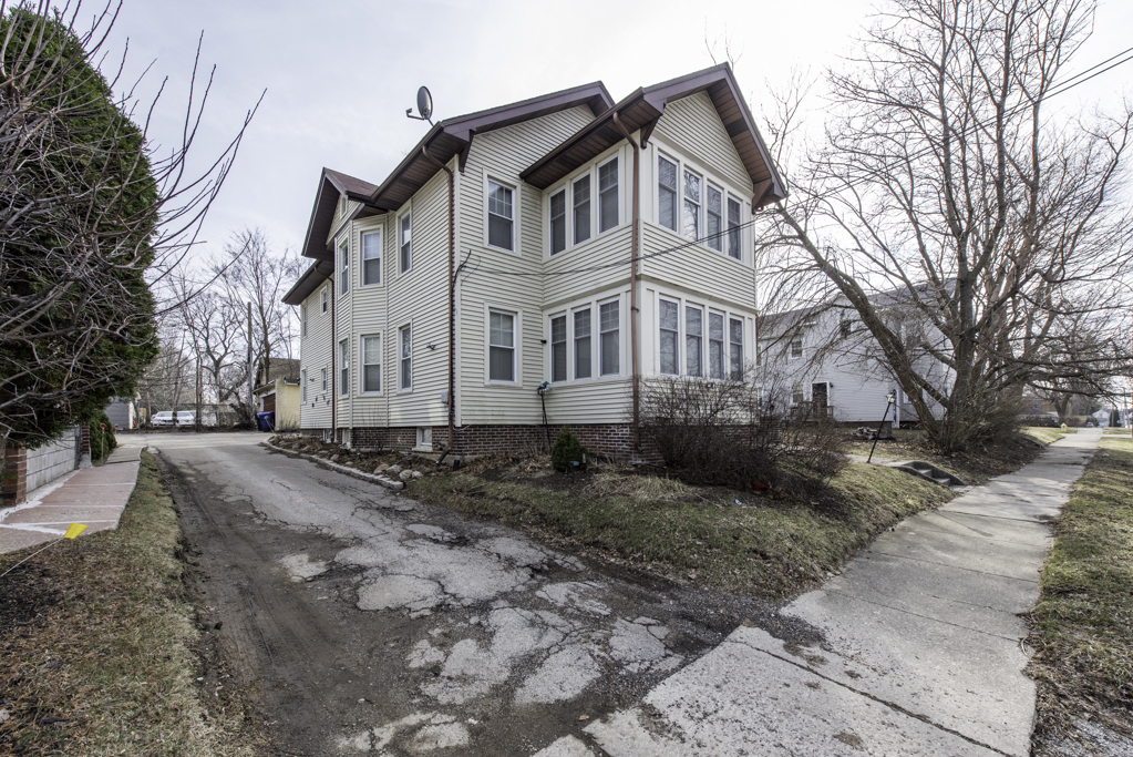 515 2nd Street, Unit 2 Waukegan, IL 60085 - Photo 3 of 27 a view of a white house with a large tree covered in snow
