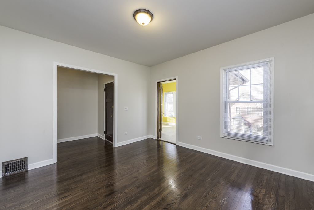 515 2nd Street, Unit 2 Waukegan, IL 60085 - Photo 6 of 27 an empty room with wooden floor and windows