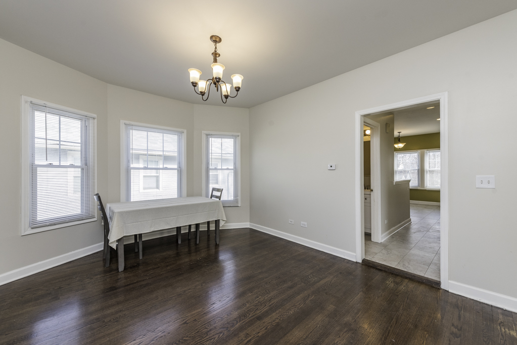 515 2nd Street, Unit 2 Waukegan, IL 60085 - Photo 8 of 27 an empty room with wooden floor chandelier and windows