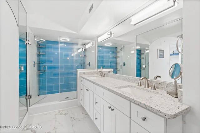 a bathroom with a granite countertop sink mirror and shower