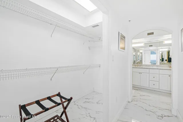 a spacious bathroom with a shower a sink and a mirror