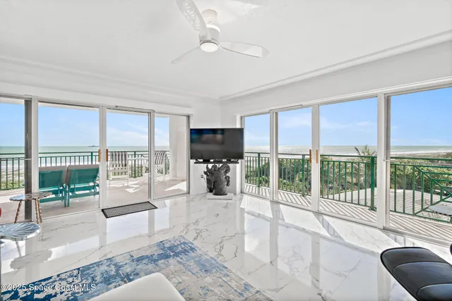 a living room with furniture floor to ceiling windows and a floor to ceiling window