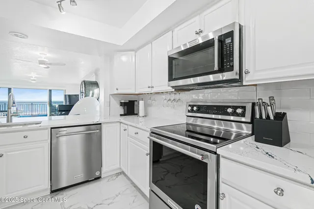 a kitchen with white cabinets and stainless steel appliances
