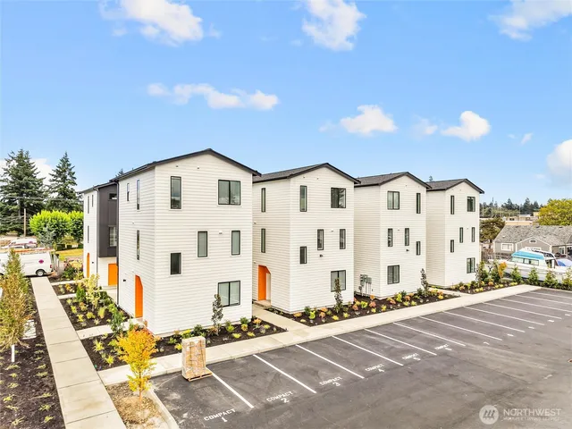 a view of a white building among the street with houses