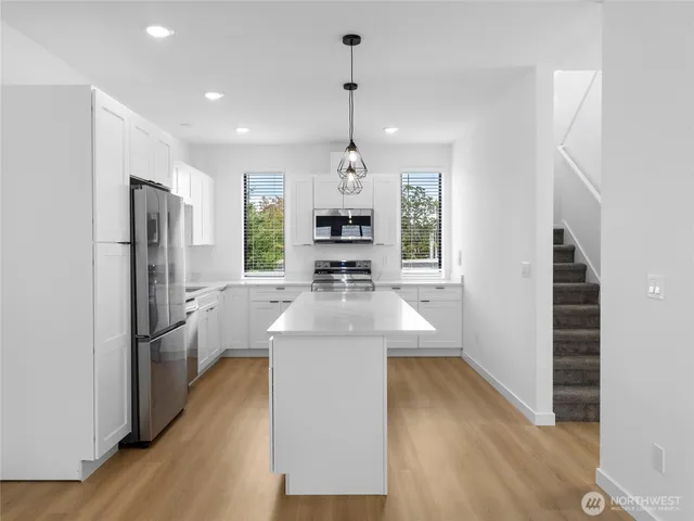 a kitchen with stainless steel appliances a stove a microwave and cabinets