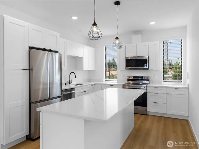 a kitchen with stainless steel appliances white cabinets and a refrigerator