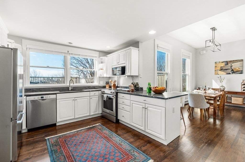 5 Babson Street, Unit 2 Gloucester, MA 01930 - Photo 11 of 30 a kitchen with granite countertop appliances cabinets and a dining table