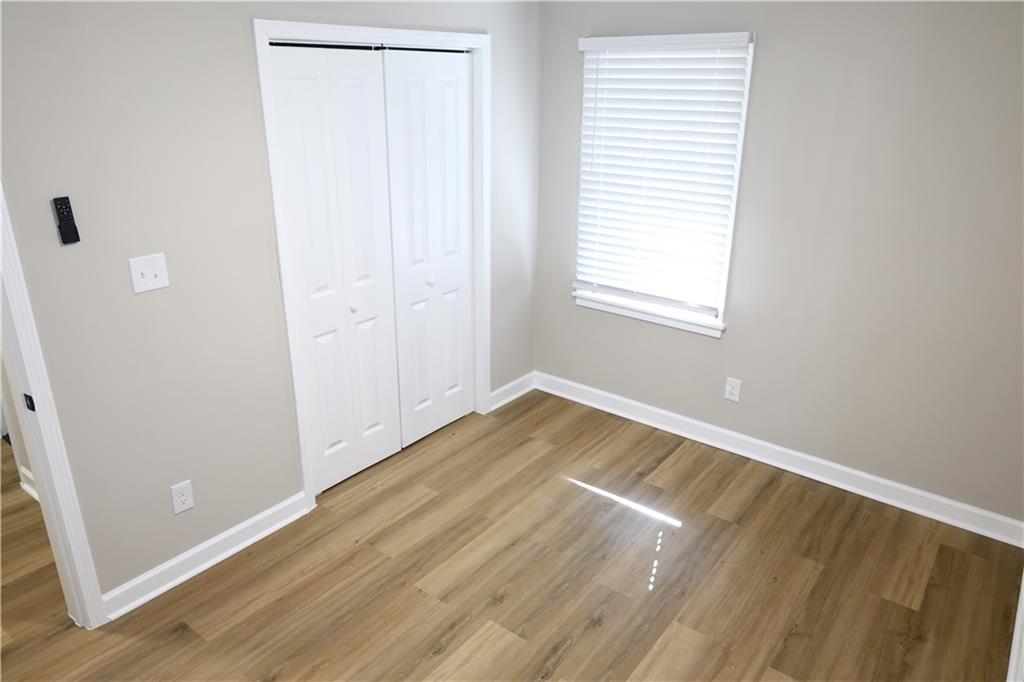 1876 Sandtown Road Southwest Atlanta, GA 30311 - Photo 10 of 20 an empty room with wooden floor and windows