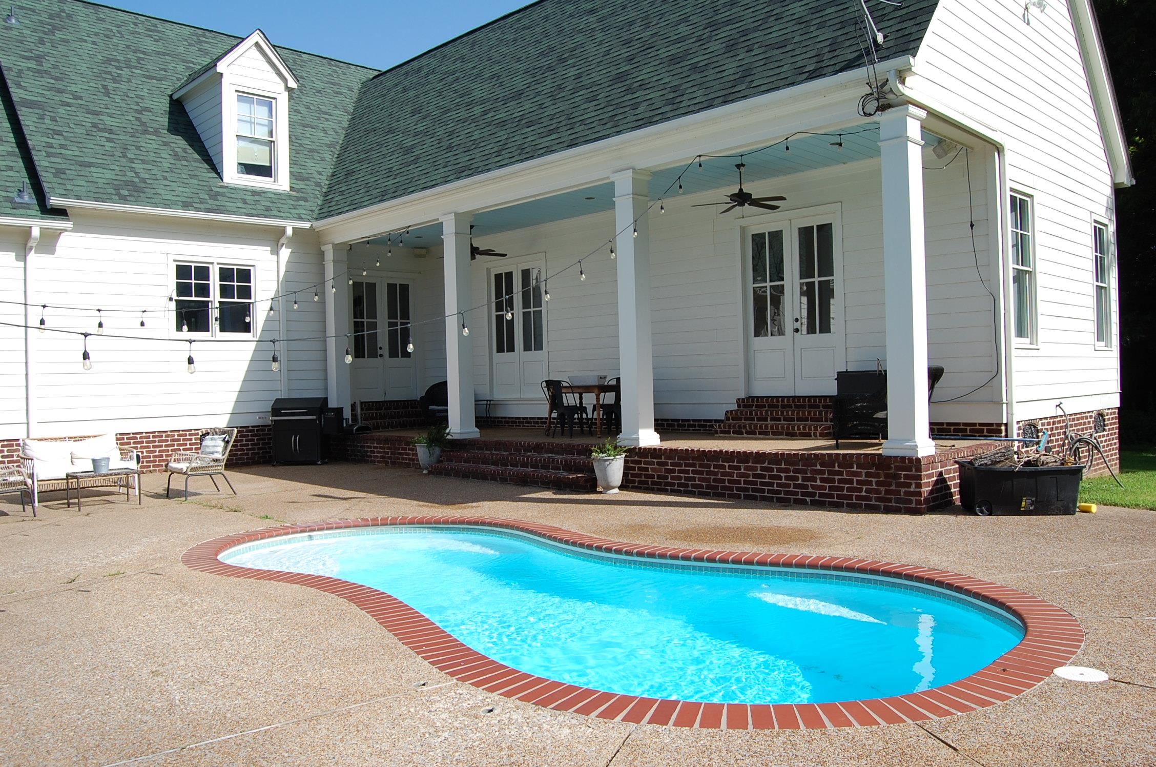1915 Teague Store Road Somerville, TN 38068 - Photo 11 of 38 Curved inground pool featuring brick coping and a surrounding concrete patio