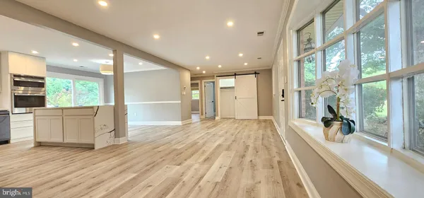 a view of a large kitchen with wooden floor and a window