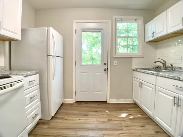 a kitchen with a refrigerator sink and cabinets