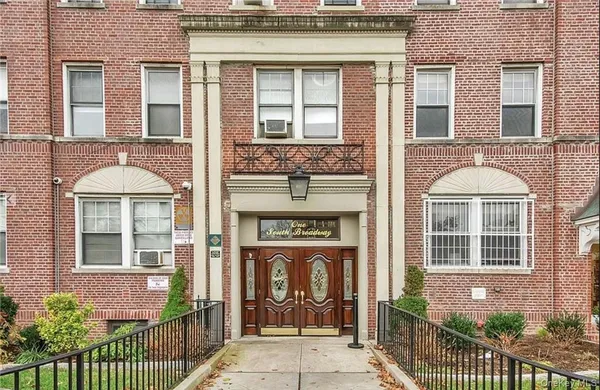 a front view of a brick building and large windows
