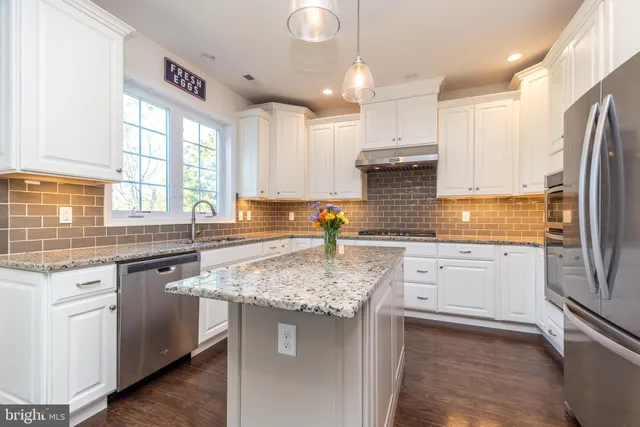 a view of an empty room with a kitchen view and a window