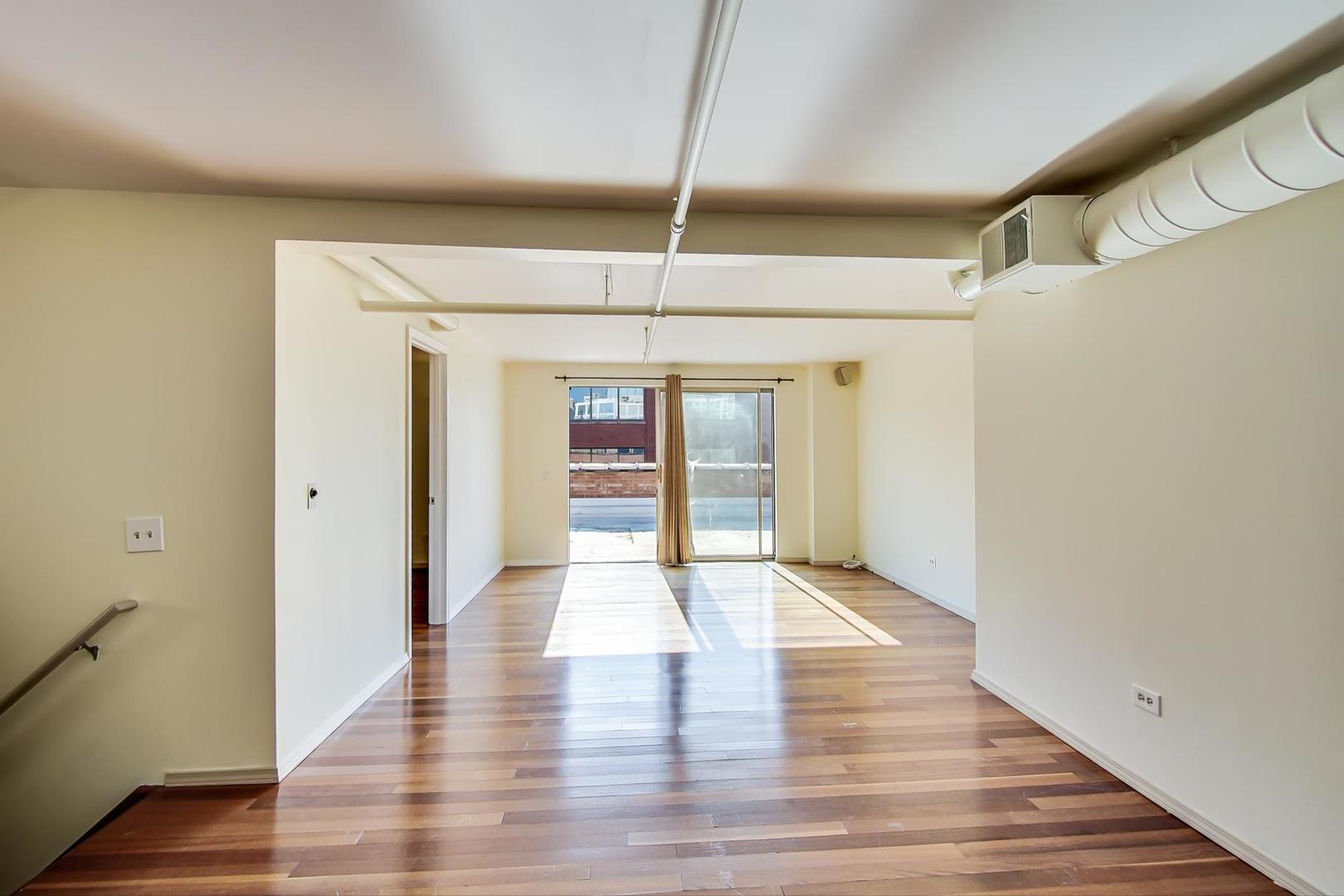 331 South Peoria Street, Unit 502 Chicago, IL 60607 - Photo 15 of 32 a view of an empty room with wooden floor and a window