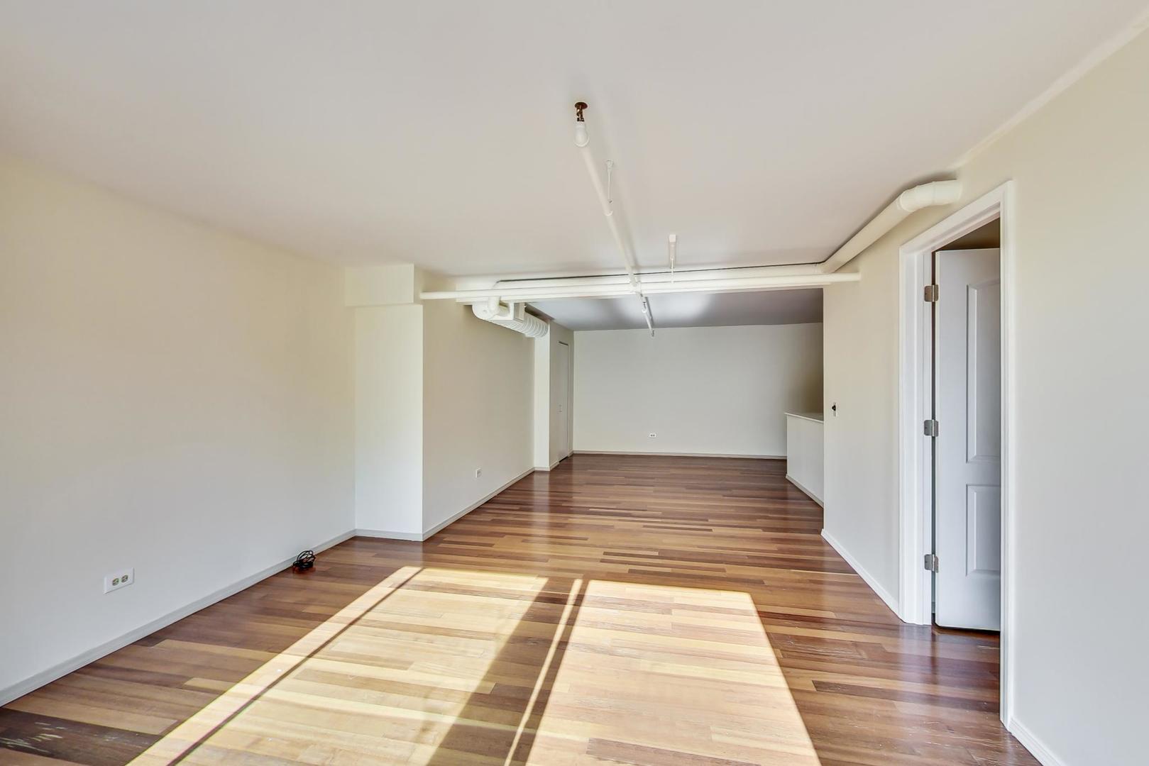 331 South Peoria Street, Unit 502 Chicago, IL 60607 - Photo 16 of 32 a view of a hallway with wooden floor