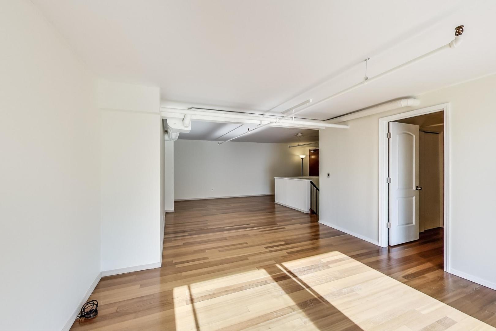 331 South Peoria Street, Unit 502 Chicago, IL 60607 - Photo 18 of 32 a view of a room with wooden floor and staircase