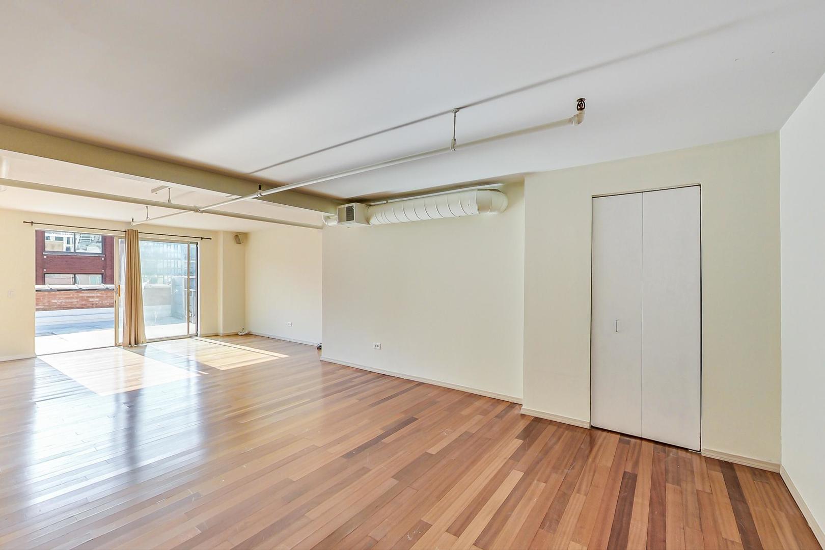 331 South Peoria Street, Unit 502 Chicago, IL 60607 - Photo 19 of 32 a view of an empty room with wooden floor and a window