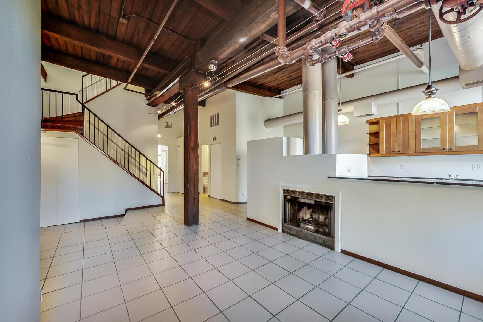 331 South Peoria Street, Unit 502 Chicago, IL 60607 - Photo 3 of 32 a view of a livingroom with an empty space and a fireplace