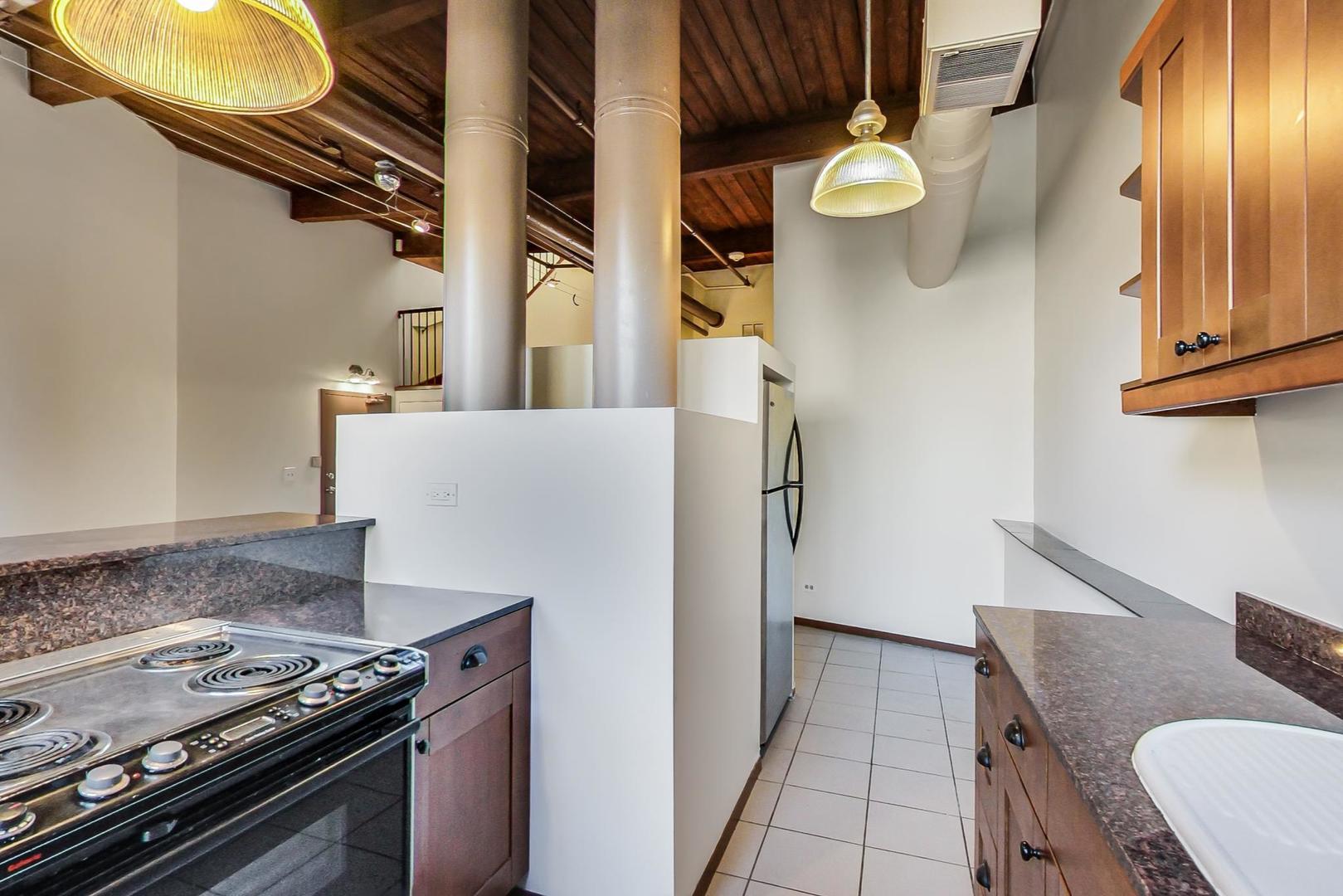 331 South Peoria Street, Unit 502 Chicago, IL 60607 - Photo 6 of 32 a kitchen with stainless steel appliances granite countertop a stove and a sink