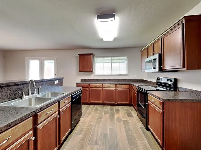 a kitchen with a sink stove top oven and microwave