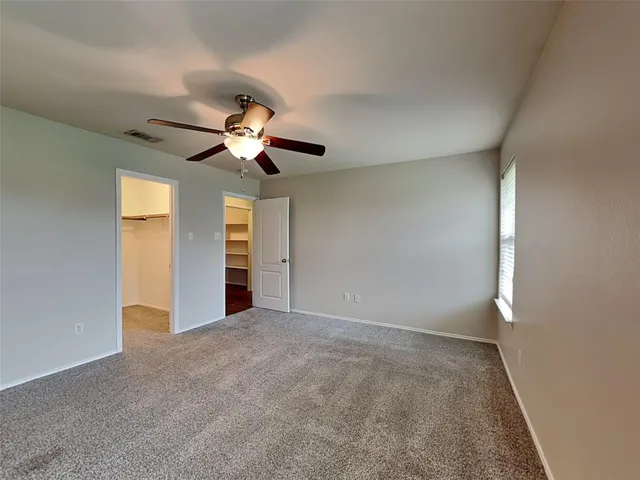 a view of an empty room with a chandelier fan