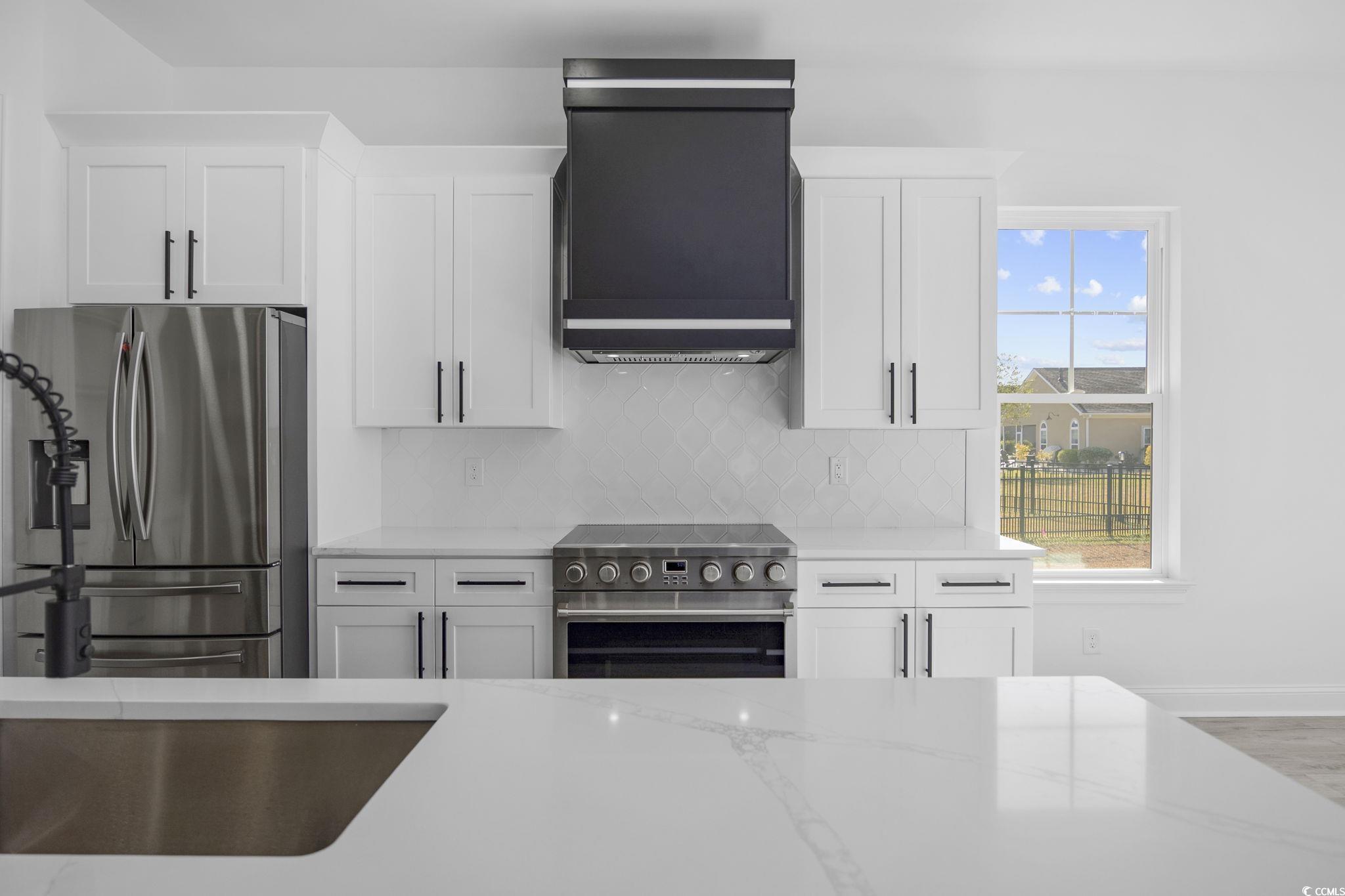 125 Lac Courte Myrtle Beach, SC 29579 - Photo 14 of 40 Kitchen with stainless steel appliances, tasteful backsplash, and white cabinetry