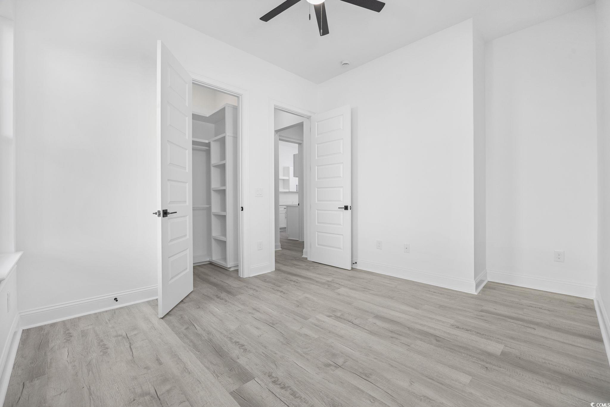 125 Lac Courte Myrtle Beach, SC 29579 - Photo 31 of 40 Unfurnished bedroom featuring light wood finished floors, a walk in closet, and ceiling fan