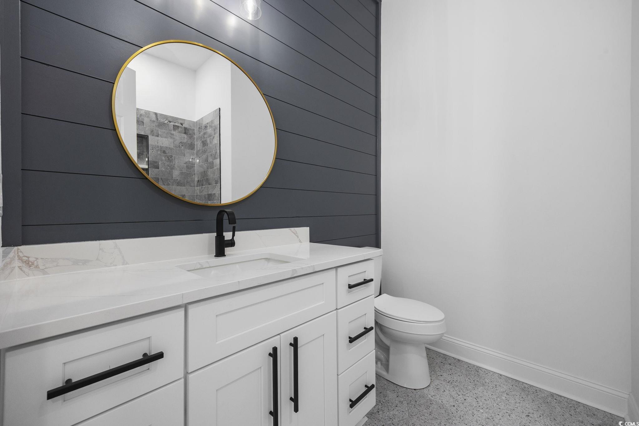 125 Lac Courte Myrtle Beach, SC 29579 - Photo 32 of 40 Full bathroom featuring dark speckled floor, vanity, and wooden walls