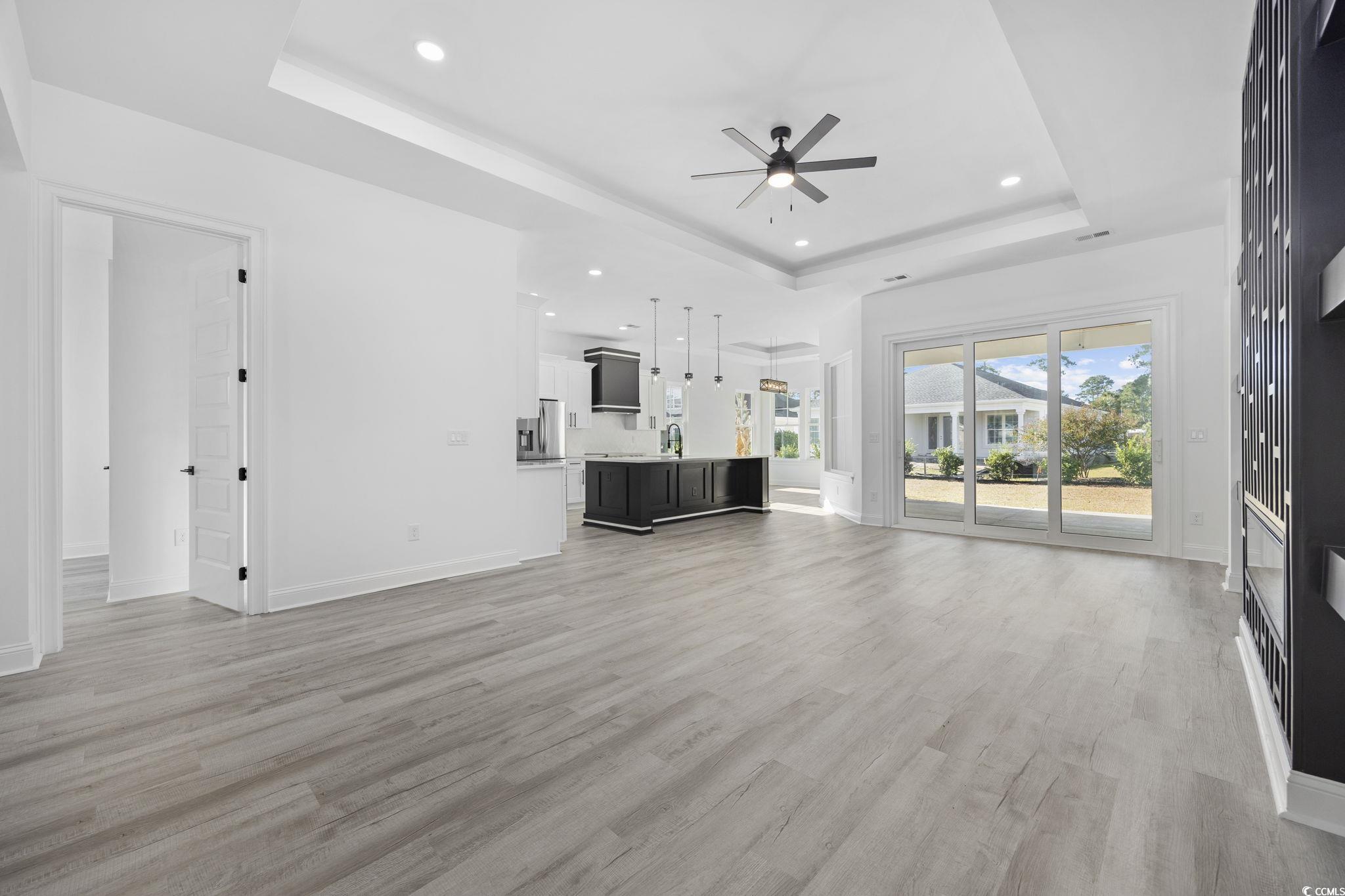125 Lac Courte Myrtle Beach, SC 29579 - Photo 6 of 40 Unfurnished living room with a tray ceiling, recessed lighting, light wood-style flooring, and ceiling fan
