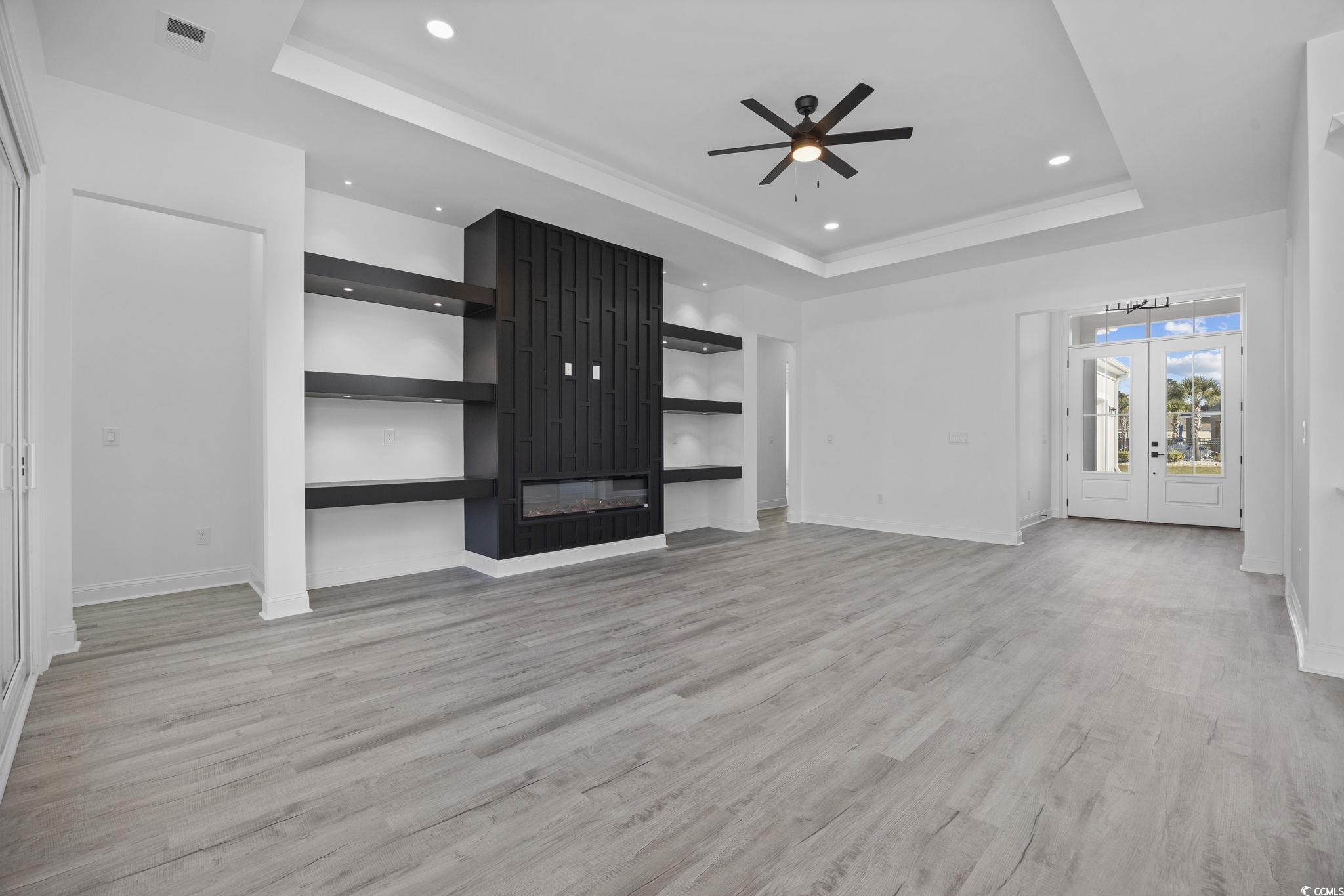 125 Lac Courte Myrtle Beach, SC 29579 - Photo 7 of 40 Unfurnished living room with a tray ceiling, light wood finished floors, french doors, and recessed lighting