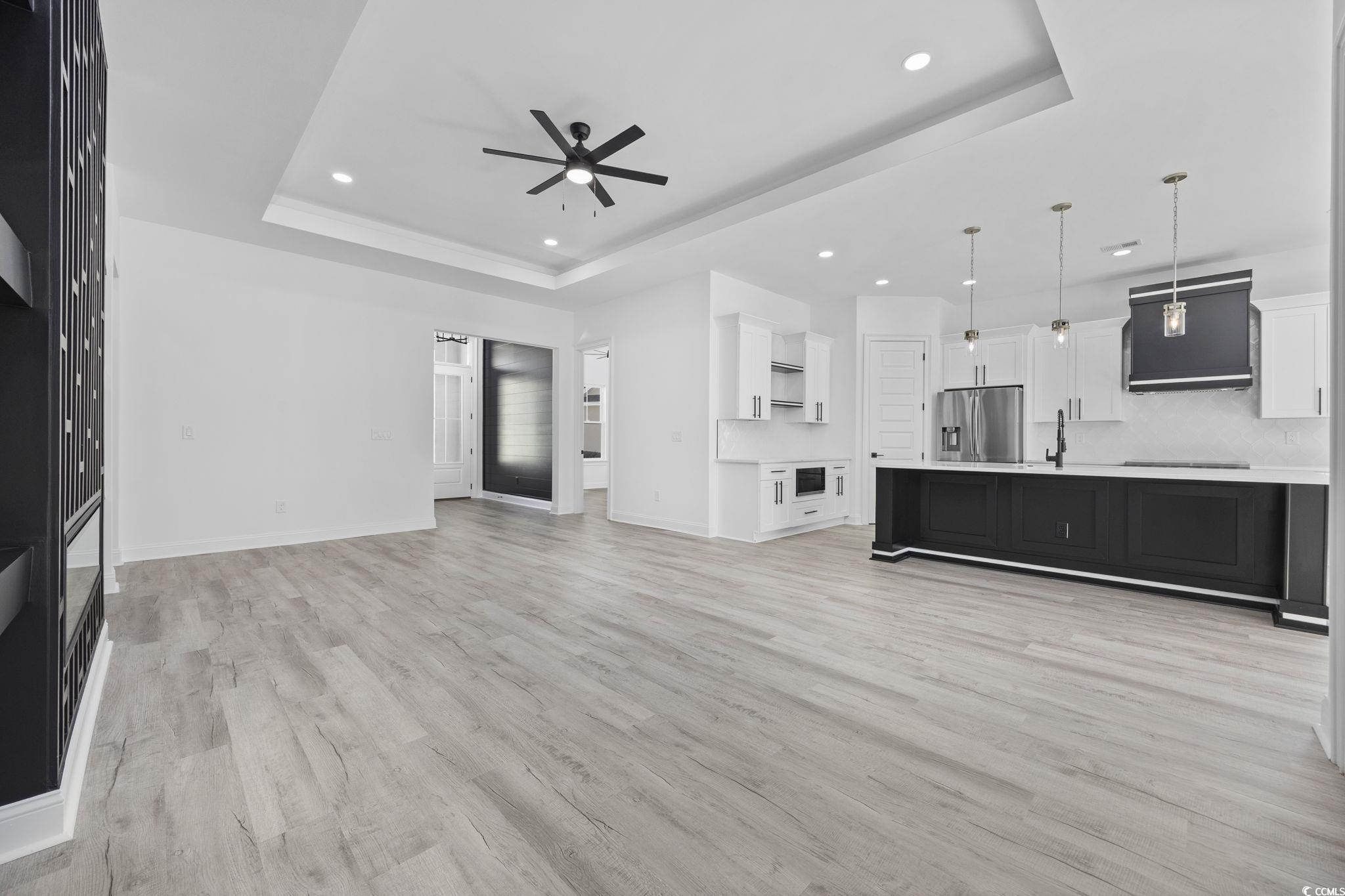 125 Lac Courte Myrtle Beach, SC 29579 - Photo 8 of 40 Unfurnished living room with a tray ceiling, recessed lighting, light wood-type flooring, and a ceiling fan