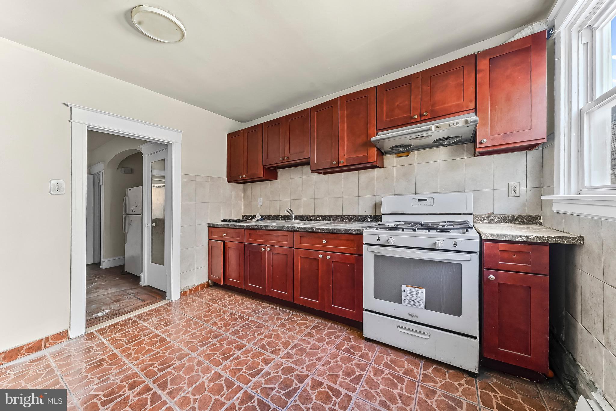 7269 Walnut Street Upper Darby, PA 19082 - Photo 11 of 17 a kitchen with stainless steel appliances granite countertop a stove a sink and a refrigerator