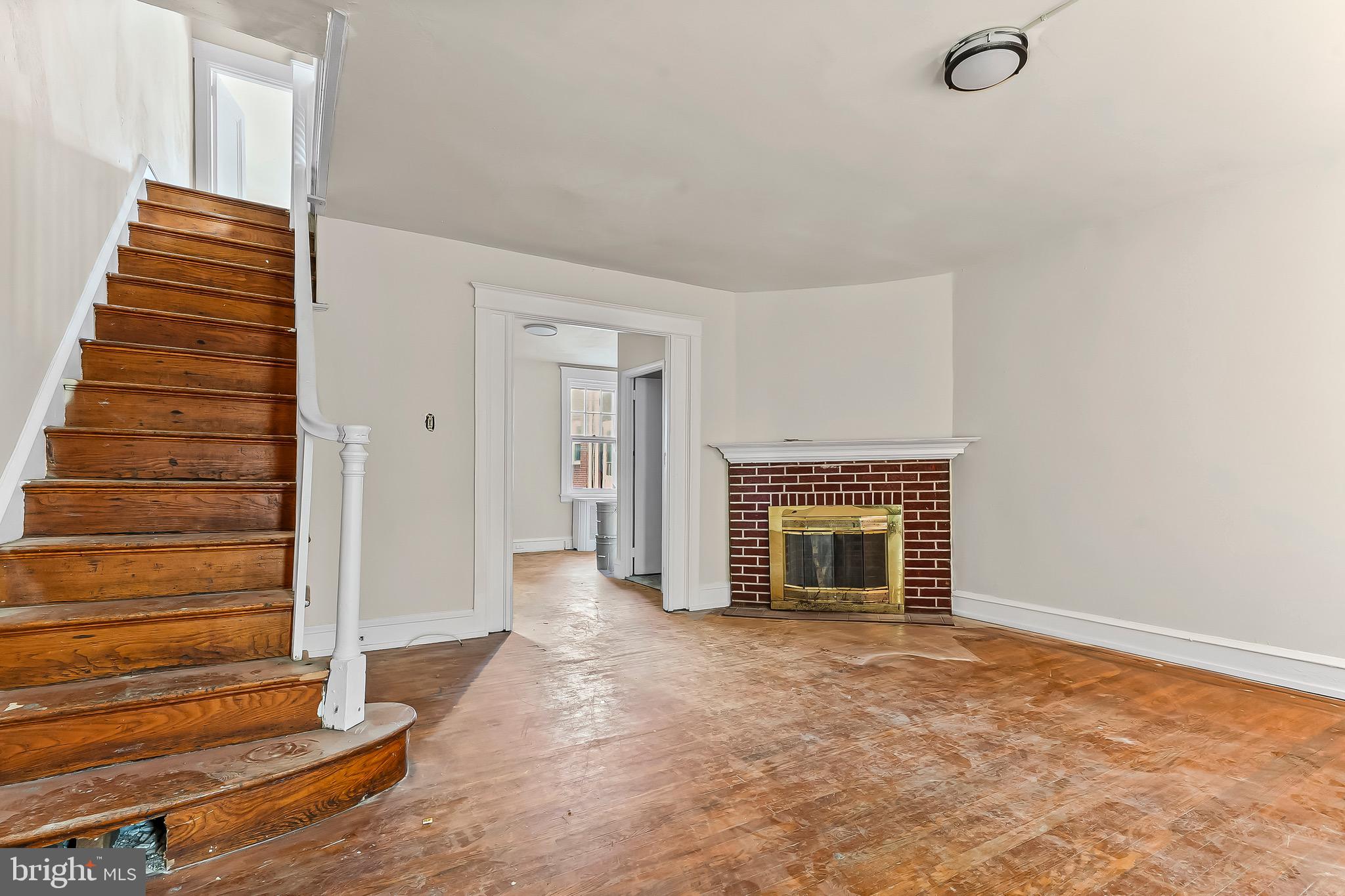 7269 Walnut Street Upper Darby, PA 19082 - Photo 3 of 17 a view of an empty room with wooden floor and stairs