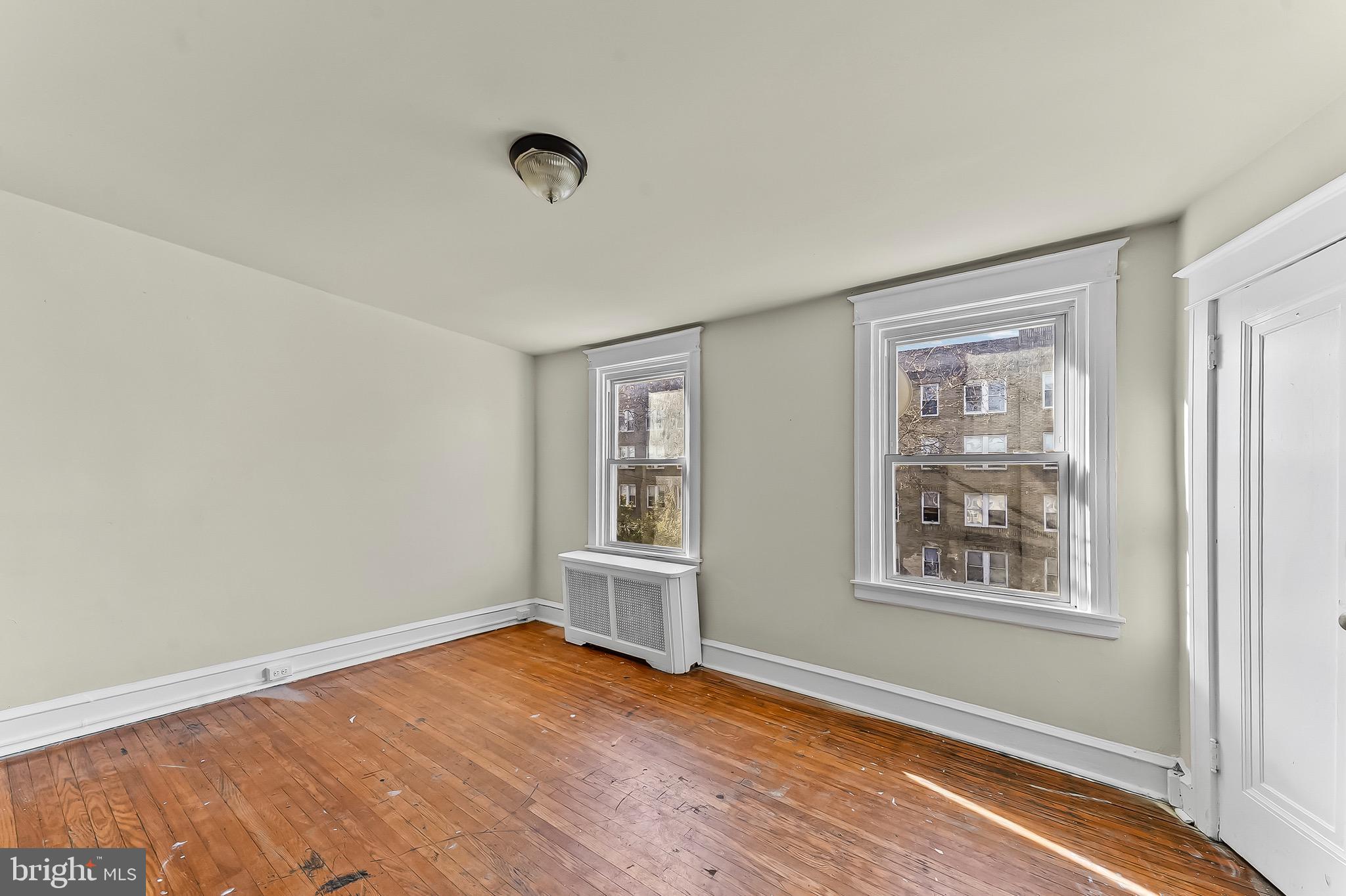 7269 Walnut Street Upper Darby, PA 19082 - Photo 7 of 17 an empty room with wooden floor and windows
