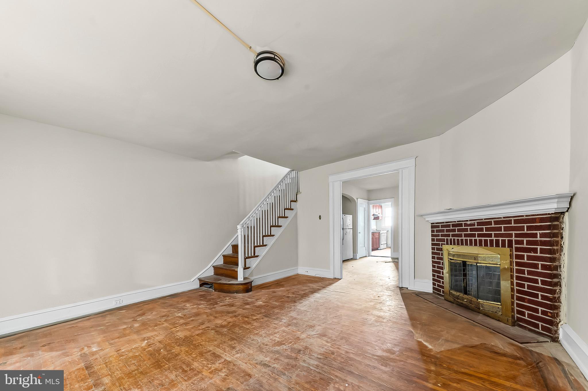 7269 Walnut Street Upper Darby, PA 19082 - Photo 8 of 17 a view of an empty room with wooden floor fireplace and a window