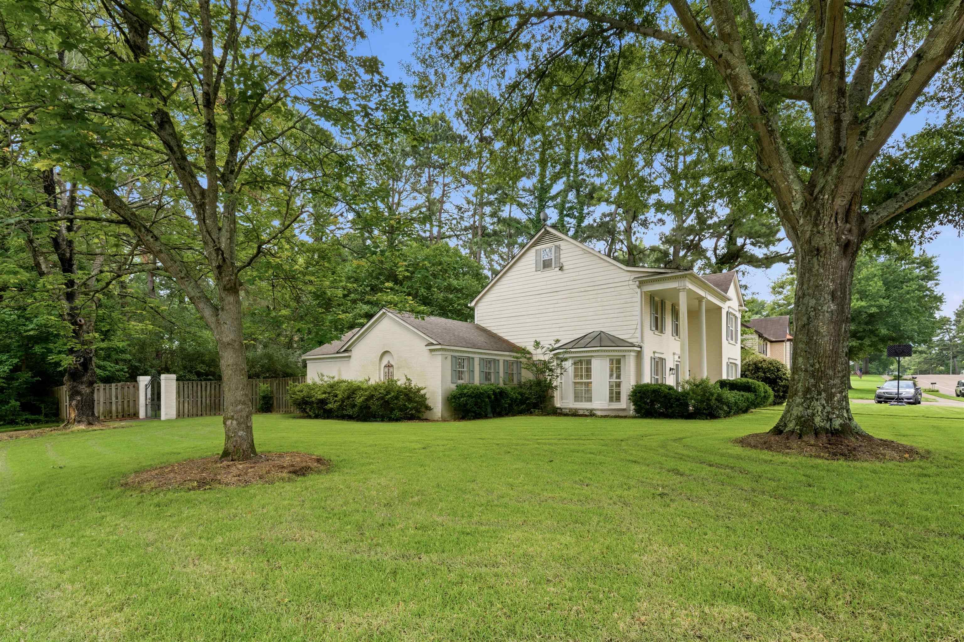 1984 Allenby Road Germantown, TN 38139 - Photo 4 of 37 Expansive green lawn surrounds a traditional-style residence with white siding and a prominent columned entrance