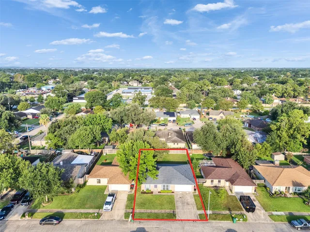 an aerial view of residential houses with outdoor space and street view