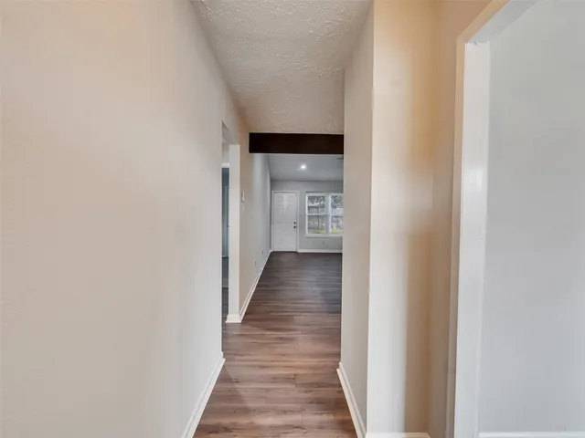 a view of a hallway with wooden floor