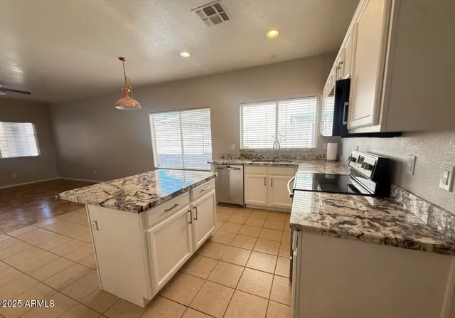 a kitchen with a stove sink and cabinets