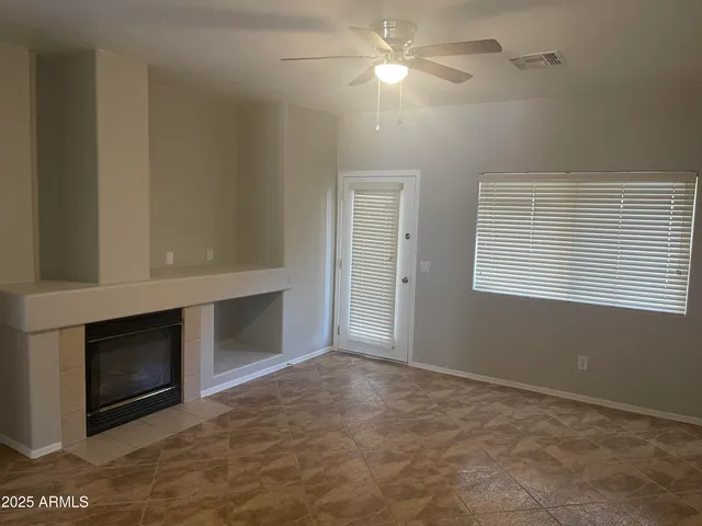 a view of an empty room with a fireplace and a window