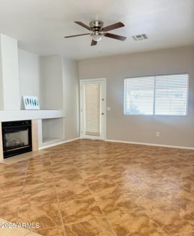 a view of an empty room with a fireplace and a window