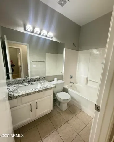 a bathroom with a granite countertop sink a toilet and a large mirror