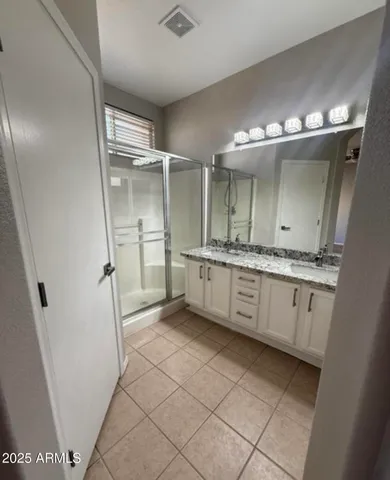 a bathroom with a granite countertop sink mirror and shower