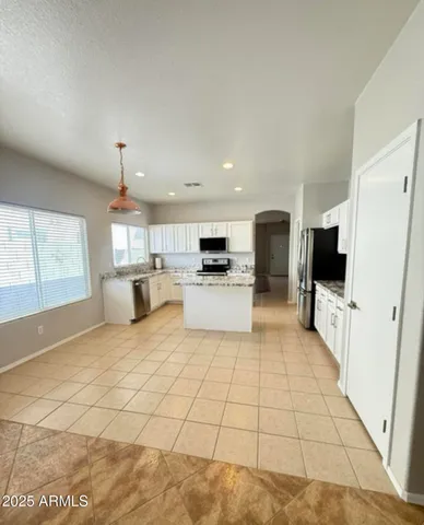 a large white kitchen with a stove a sink and a refrigerator
